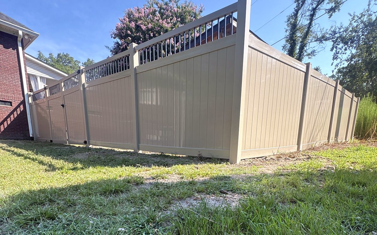 Corner of an Adobe vinyl privacy fence with a black picket top in West Columbia, SC