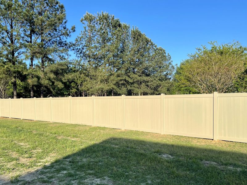 Adobe vinyl privacy fence along a green lawn in Gilbert, SC
