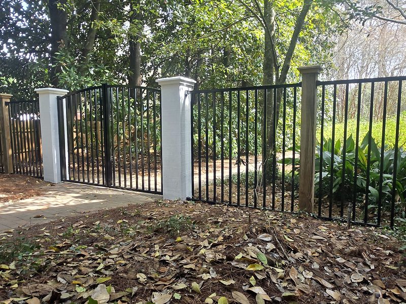 Black aluminum fence and gate with white columns after replacement in Columbia, SC