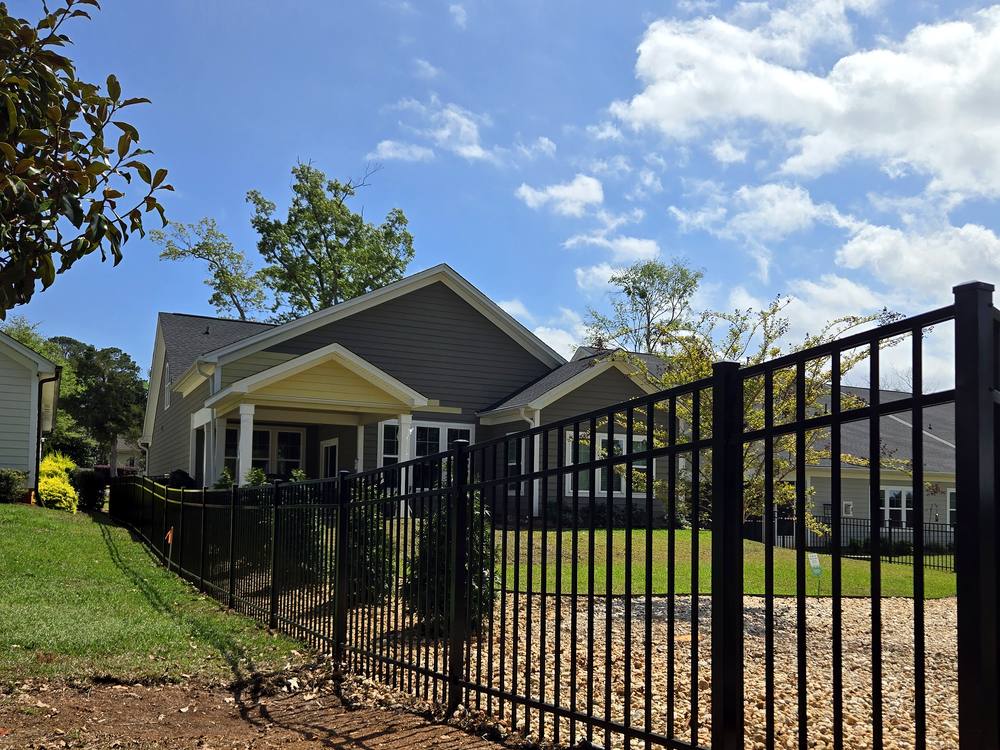 Black aluminum fence and gate in front of a craftsman style home in the Midlands of South Carolina