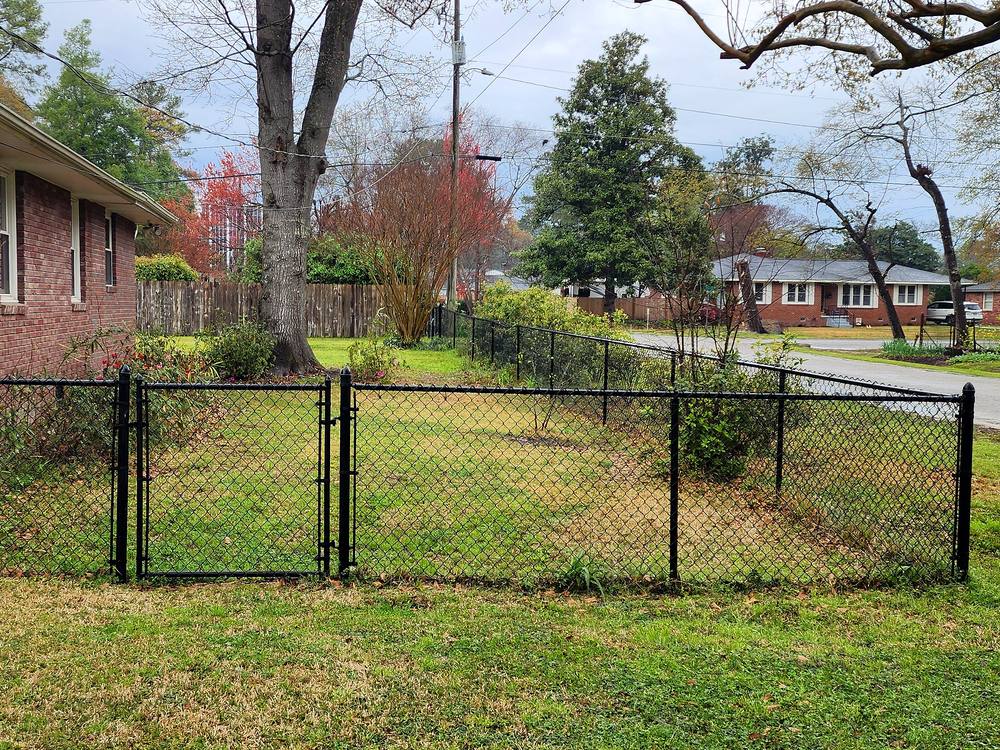 Black chain link fence and walk gate in front of a brick home in the Midlands of SC
