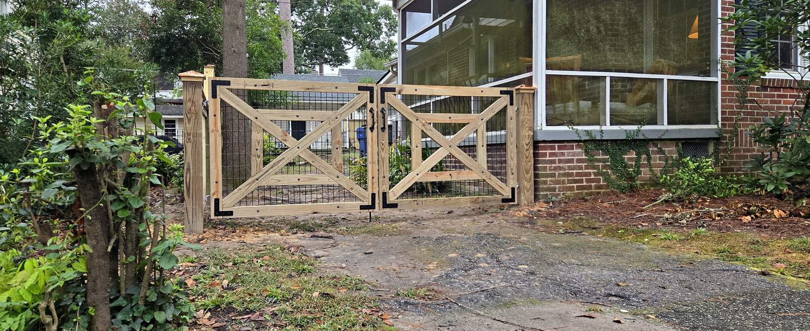 Custom wood double gate with X bracing and wire mesh infill in the Midlands of South Carolina