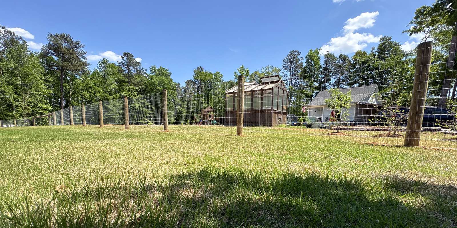 Wood post and wire farm fence enclosing an open pasture in the Midlands of South Carolina