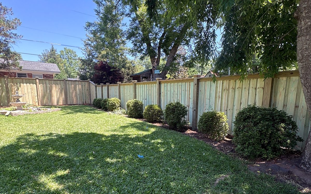 New wood cap and trim privacy fence along a green backyard in Irmo, SC