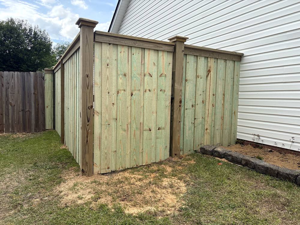 New wood privacy fence with a boxed corner and cap along the side of a home in the Midlands of South Carolina