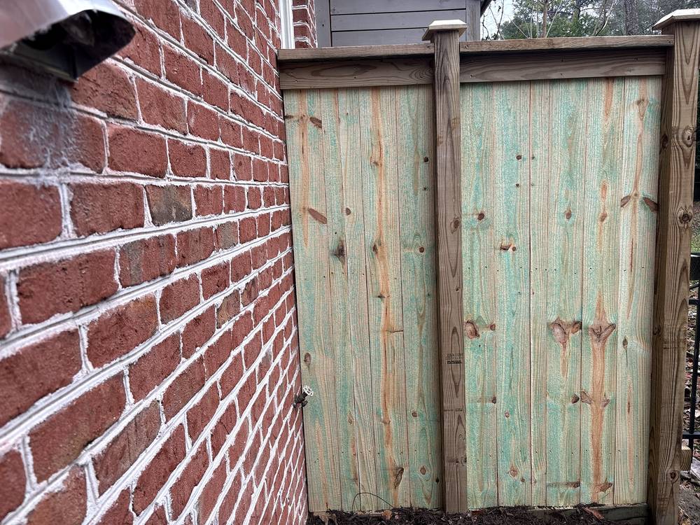 New wood privacy gate beside a brick wall in Columbia, SC