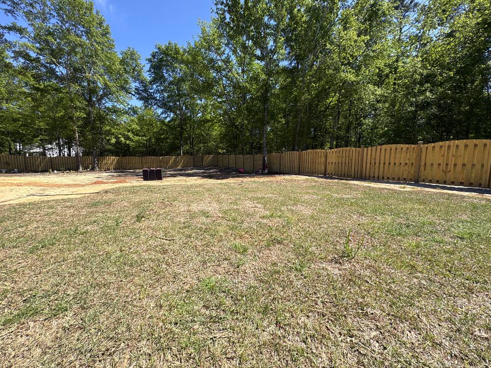 Long run of wood shadowbox fence with a scalloped top across a backyard in Irmo, SC