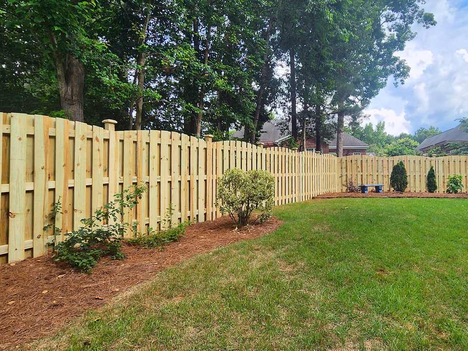 Wood shadowbox privacy fence with a level top line along a lawn in the Midlands of South Carolina